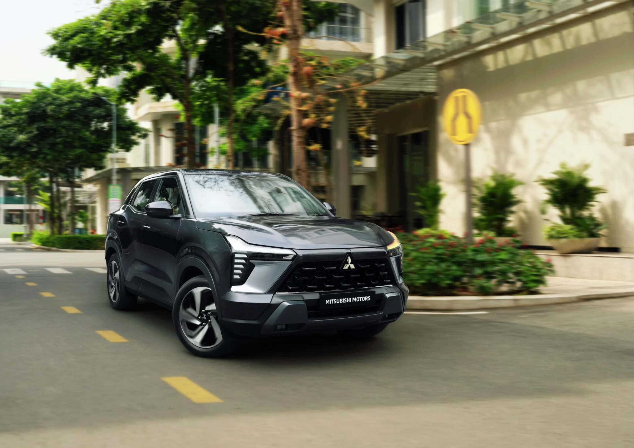 Mitsubishi Outlander Sport driving through a tree-lined city street